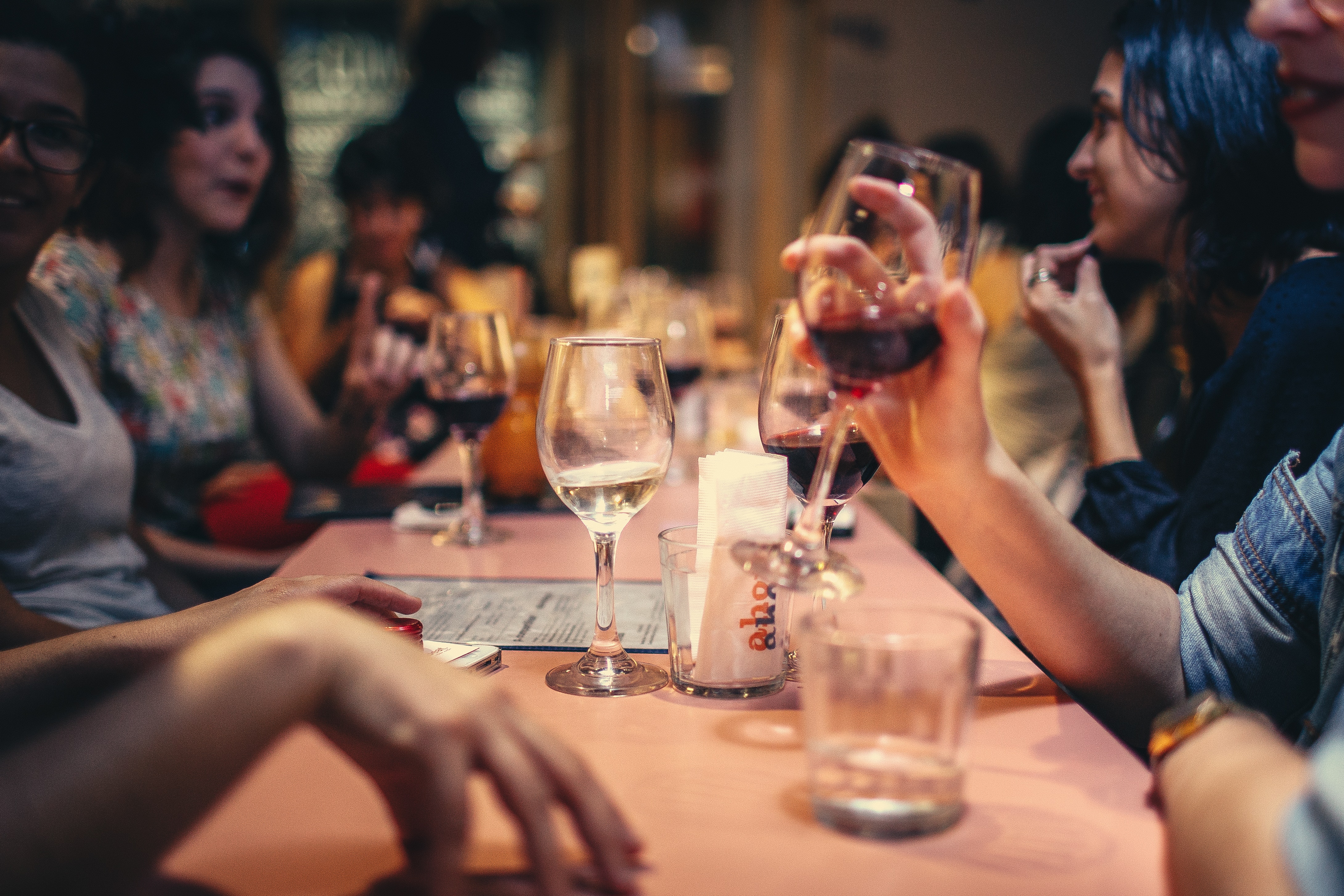 People drinking liquor and talking on dining table close-up photo