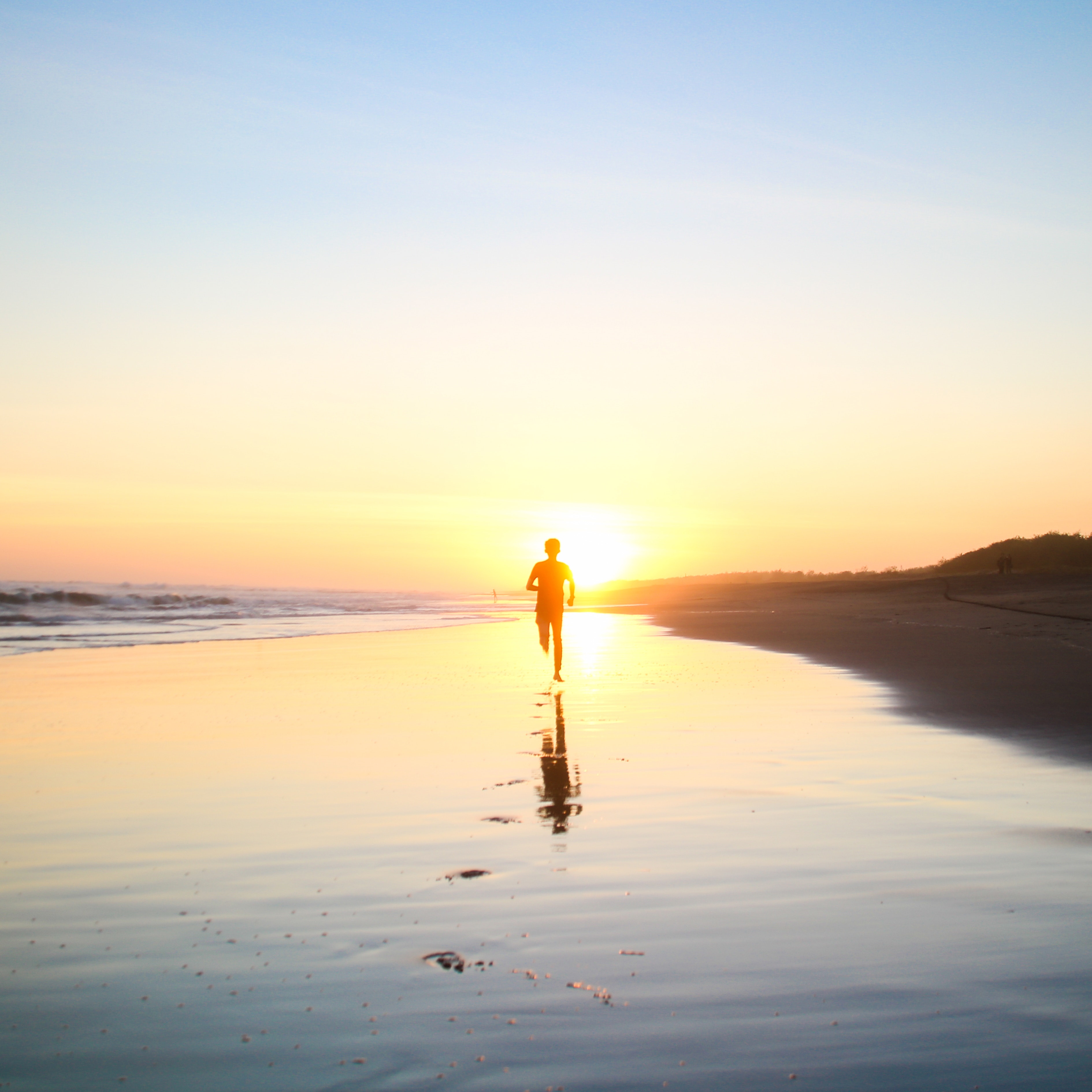Silhouette of boy running in body of water during sunset photo
